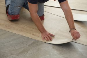 Worker installing new vinyl tile floor